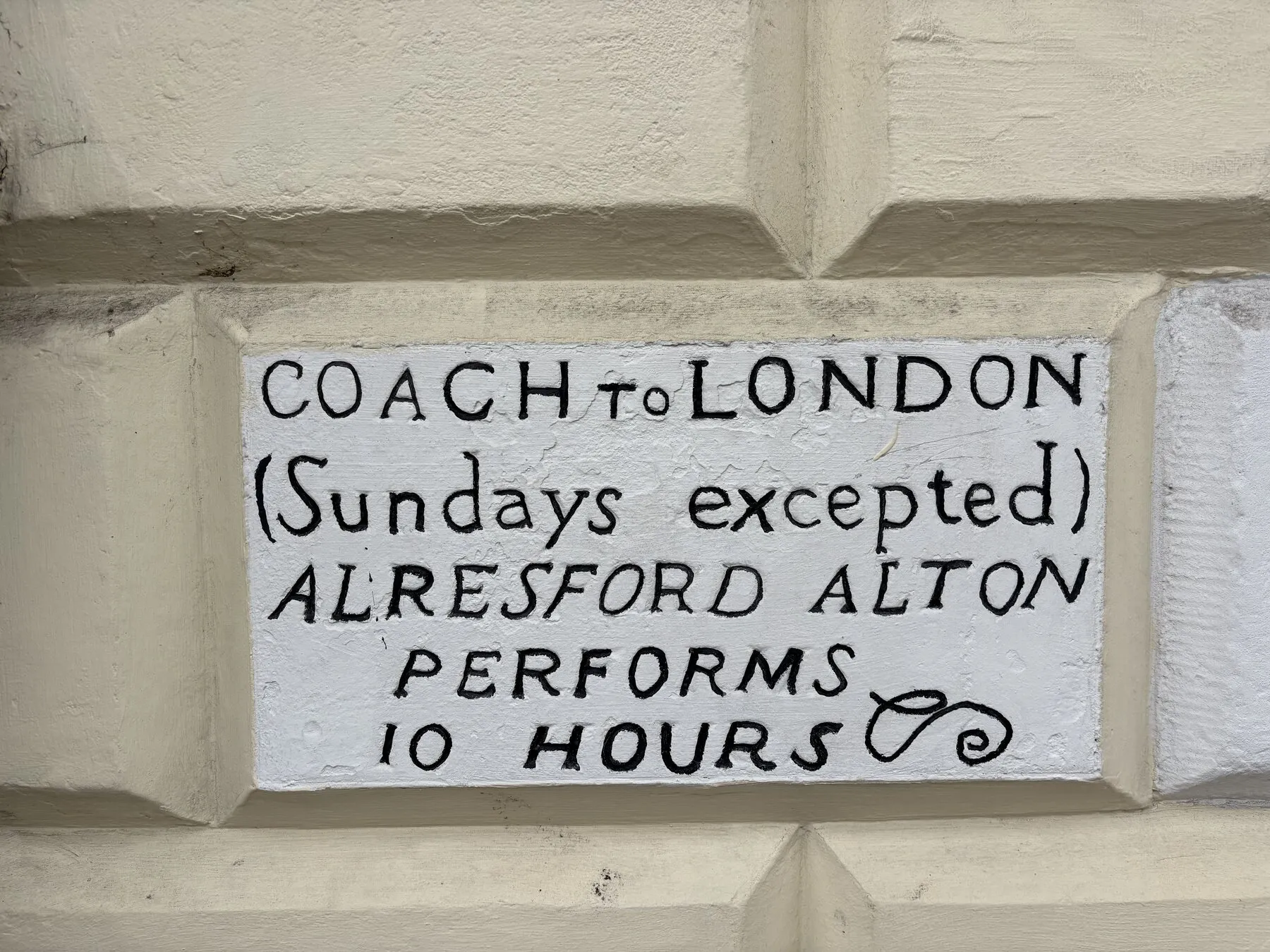 A historic coach to London sign painted on a Southampton wall
