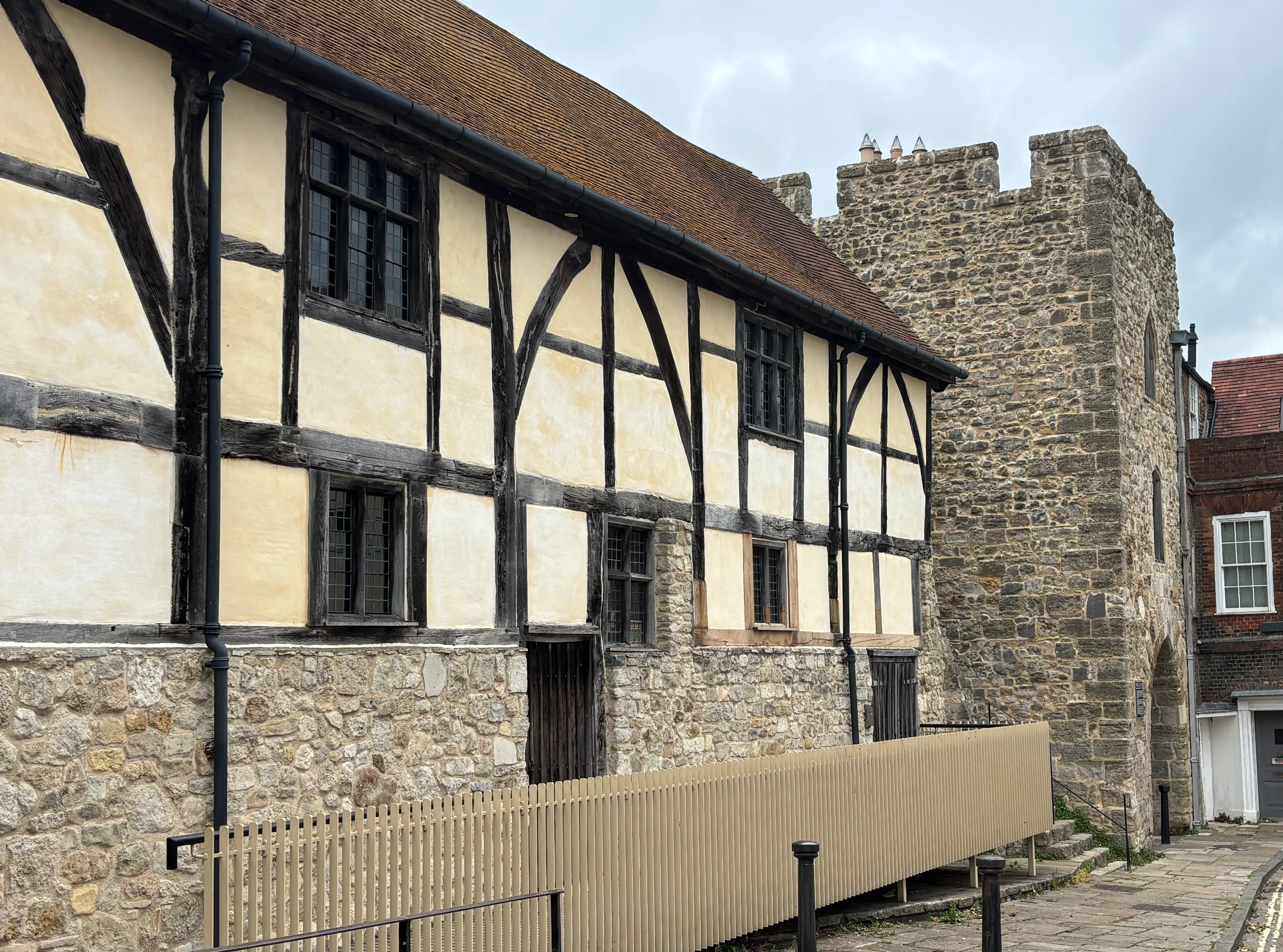 A timber-framed historic building beside Southampton's stone town wall